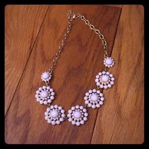 A white and gold flowery necklace.